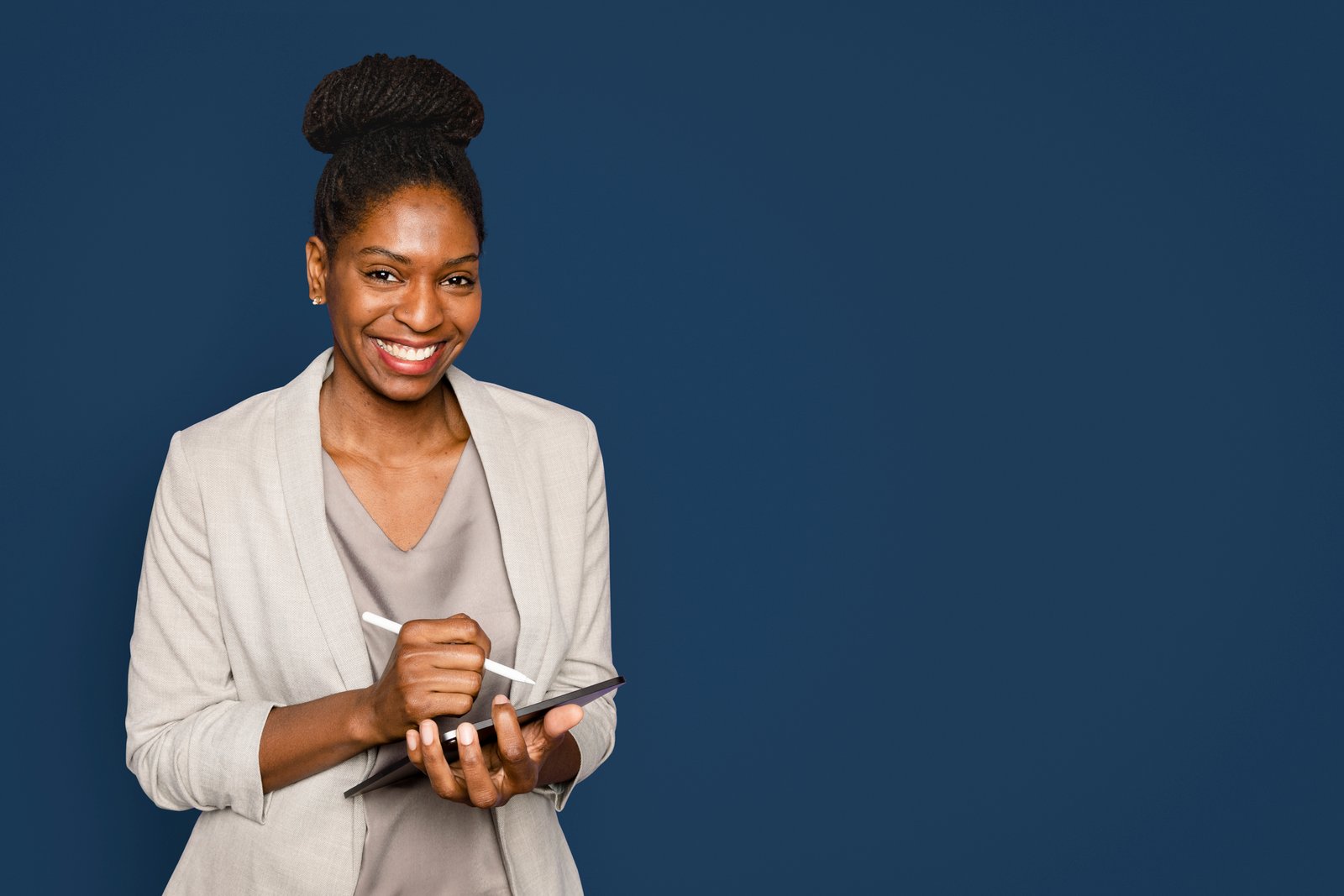 smiling woman writing notes on digital device.